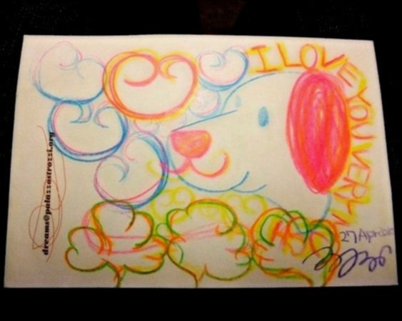 Colorful crayon drawing of a whimsical curly dog-like face in pink, orange, and green, with the handwritten words 'I love you very'